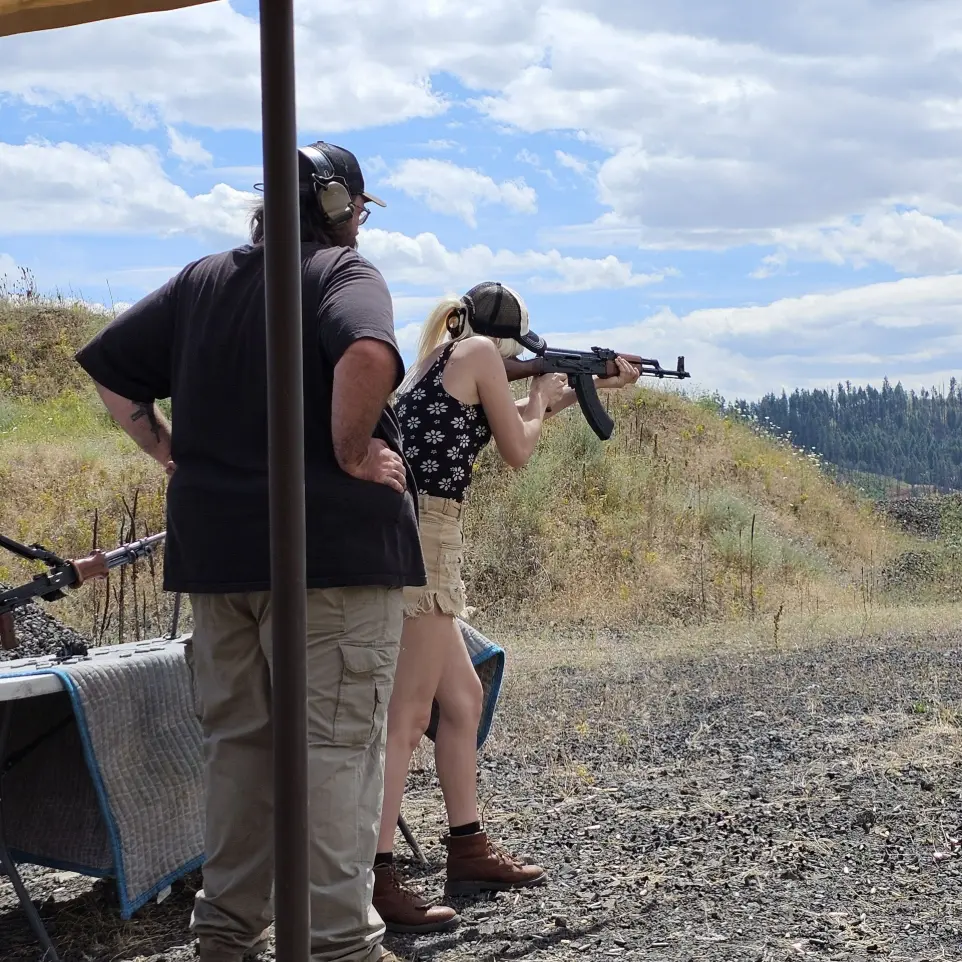 Two men seeing shooting a firearm
